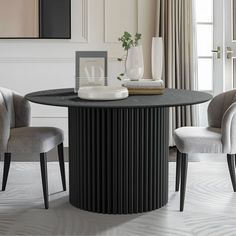 a dining room table with two chairs and a vase on the table next to it