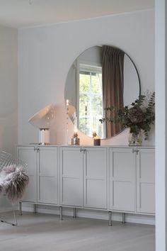 a room with a large mirror and white furniture