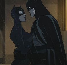 batman and catwoman standing in the rain