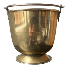 an antique brass urn with a woman in the reflection on it's side