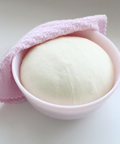 a bowl with a pink cloth on it and a ball of bread in the middle