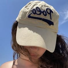 a woman wearing a baseball cap with the word poco on it's side