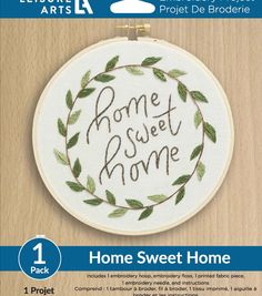 the home sweet home embroidery kit is shown in front of a wooden background with text on it