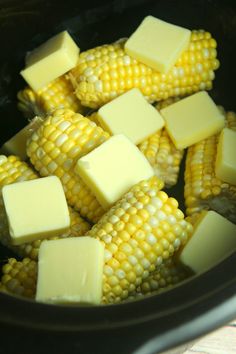 corn on the cob with butter and butter cubes in a slow cooker