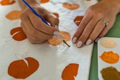 a person is doing crafts with oranges on paper