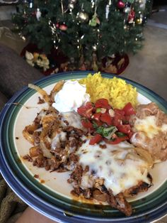 a blue and white plate topped with food next to a christmas tree