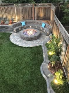 an outdoor fire pit surrounded by green grass