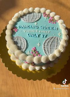 a cake with white frosting and blue icing that reads dancing queen young & sweet only