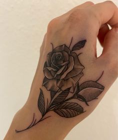 a hand with a rose tattoo on it