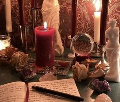 an open book sitting on top of a table next to candles