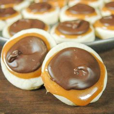 chocolate covered doughnuts sitting on top of a wooden table