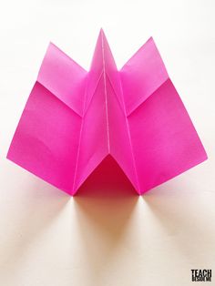 an origami flower on a white surface