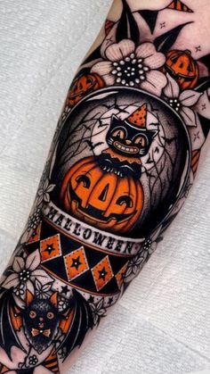 a person with a tattoo on their arm that has an image of a cat and pumpkin