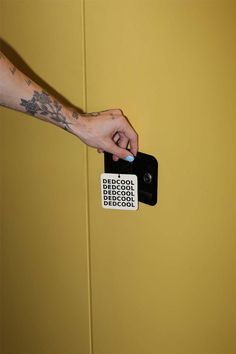 a person is holding a remote control in their hand and pressing it on the wall