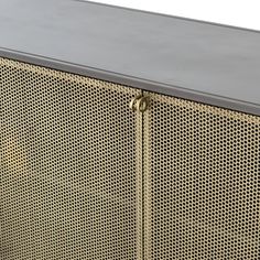 the side view of a metal cabinet with mesh coverings and brass hardware on it