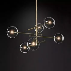 a chandelier hanging from the ceiling with five clear glass orbs on it