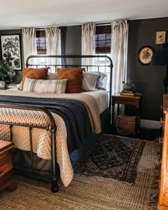 a bed sitting in a bedroom next to a window with curtains on the windowsill