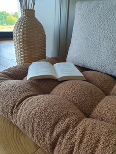 an open book sitting on top of a brown couch