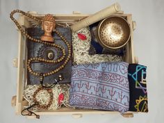 an open box with items inside it including a buddha head, beads and other accessories