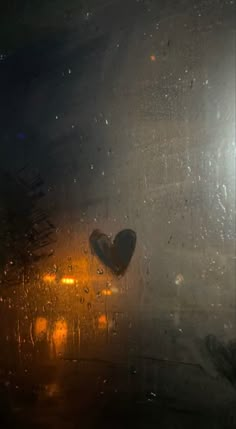 a heart shaped object sitting on top of a wet window