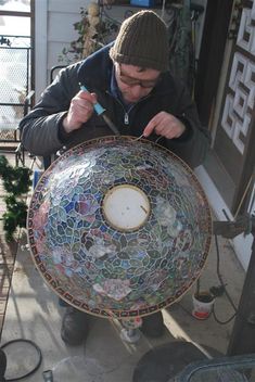 a man is working on a mosaic plate