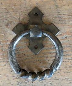 an old metal door handle on a wooden door with rope wrapped around the ring and two screws