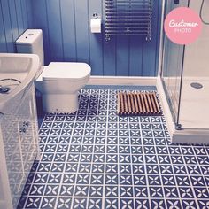 a bathroom with blue walls and flooring has a shower, toilet, sink, and bathtub