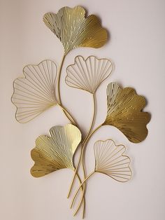 three metal leaves on a white wall