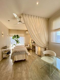 a bedroom with a glass table and white curtains