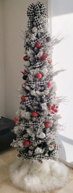 a white christmas tree with red and black ornaments