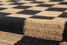 a black and tan checkered rug is laying on the floor