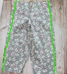 a pair of leggings with green trim on the side and flowers all over them