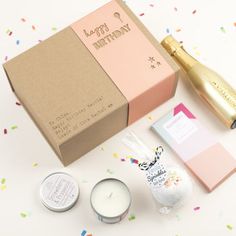 an open gift box with candles, confetti and other items next to it