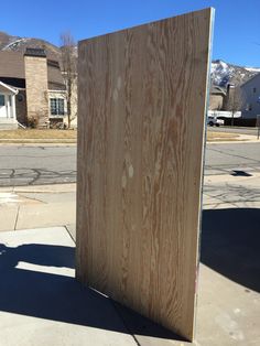 a large piece of wood sitting on the side of a road next to a building