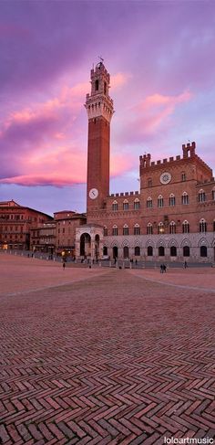 a large brick building with a clock tower in the middle of it's courtyard