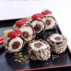 chocolate covered desserts with raspberries are on a plate, ready to be eaten