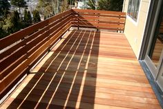 a wooden deck with benches on it and trees in the background