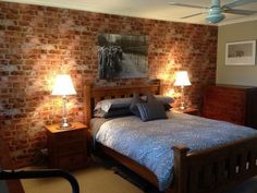 a bed room with a neatly made bed and two lamps on either side of the bed