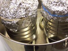 two metal pots covered in aluminum foil