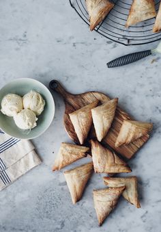 some food is laying out on a table next to a bowl and knife, along with two bowls of ice cream