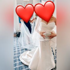 two women in wedding dresses holding red hearts