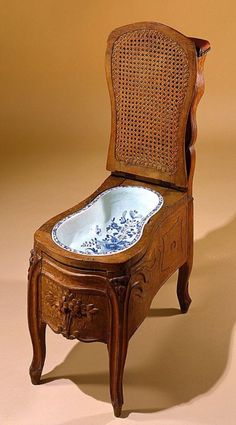 an old wooden chair with a blue and white bowl on it's back end