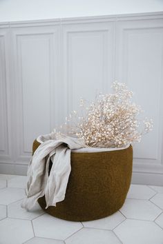 a white flower in a brown basket on the floor