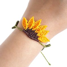 a woman's arm with a yellow and brown beaded sunflower on it