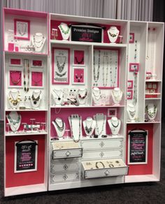 a pink and white display case filled with jewelry