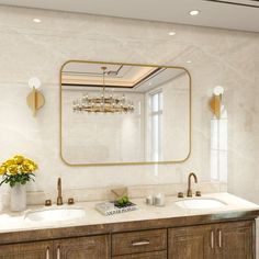 a bathroom with two sinks and a large mirror on the wall above it is decorated in gold