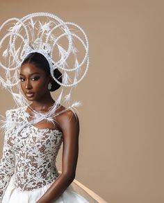 a woman in a white dress with feathers on her head