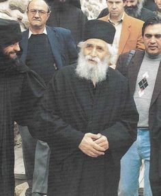 a group of men standing next to each other in front of a crowd of people