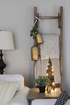 a living room with a christmas tree and potted plants on the shelf next to it