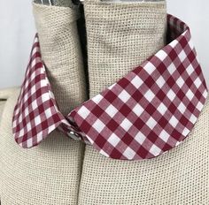 a red and white gingham necktie on a mannequin headdress